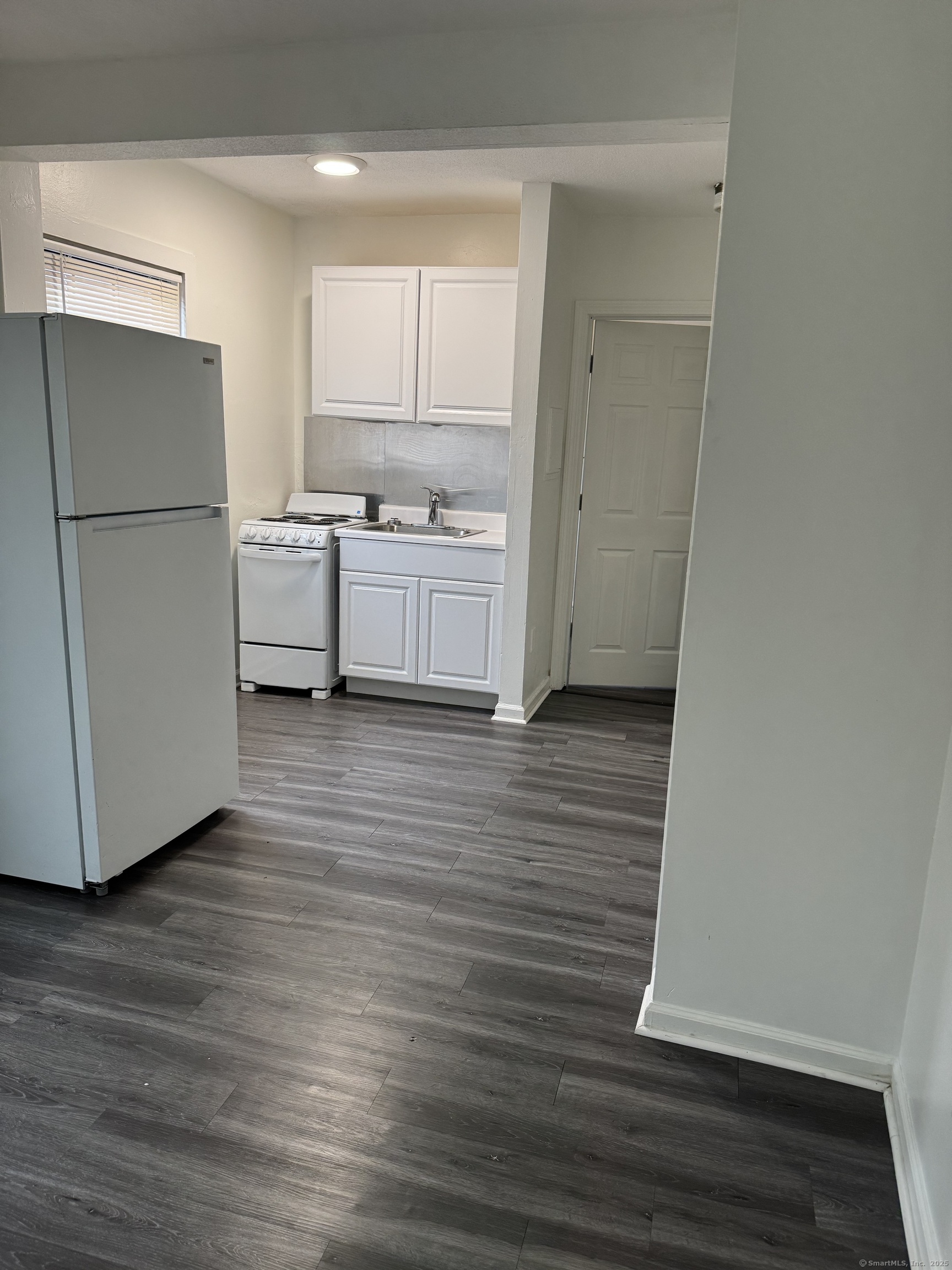 666 Main Street, Unit C4 Middletown, CT 06457 - Photo 2 of 6 a kitchen with a refrigerator a stove top oven and a wooden floor