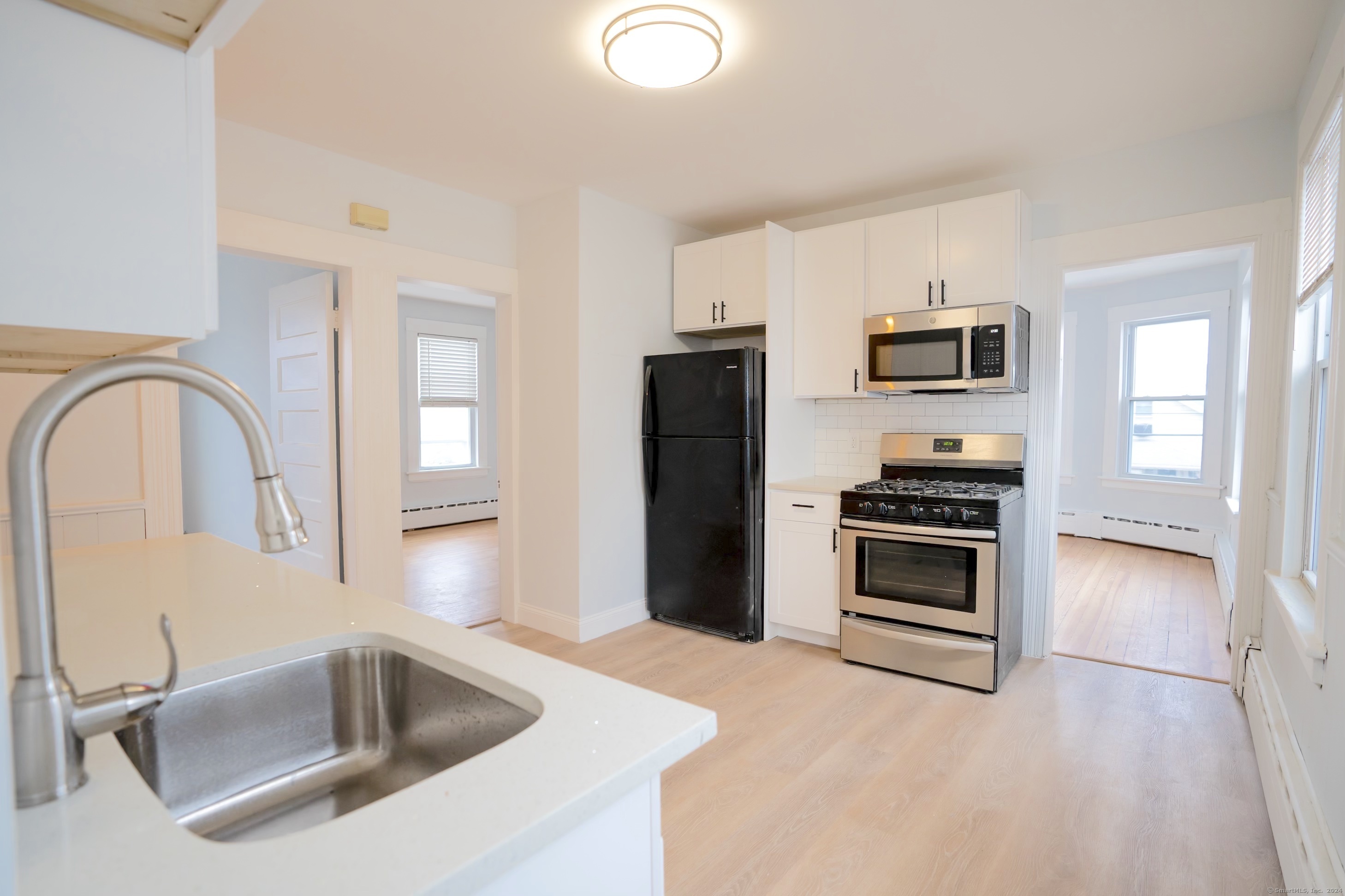 a kitchen with stainless steel appliances a stove microwave and refrigerator