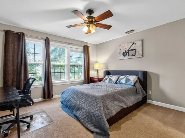 a bedroom with a bed and a painting on the wall