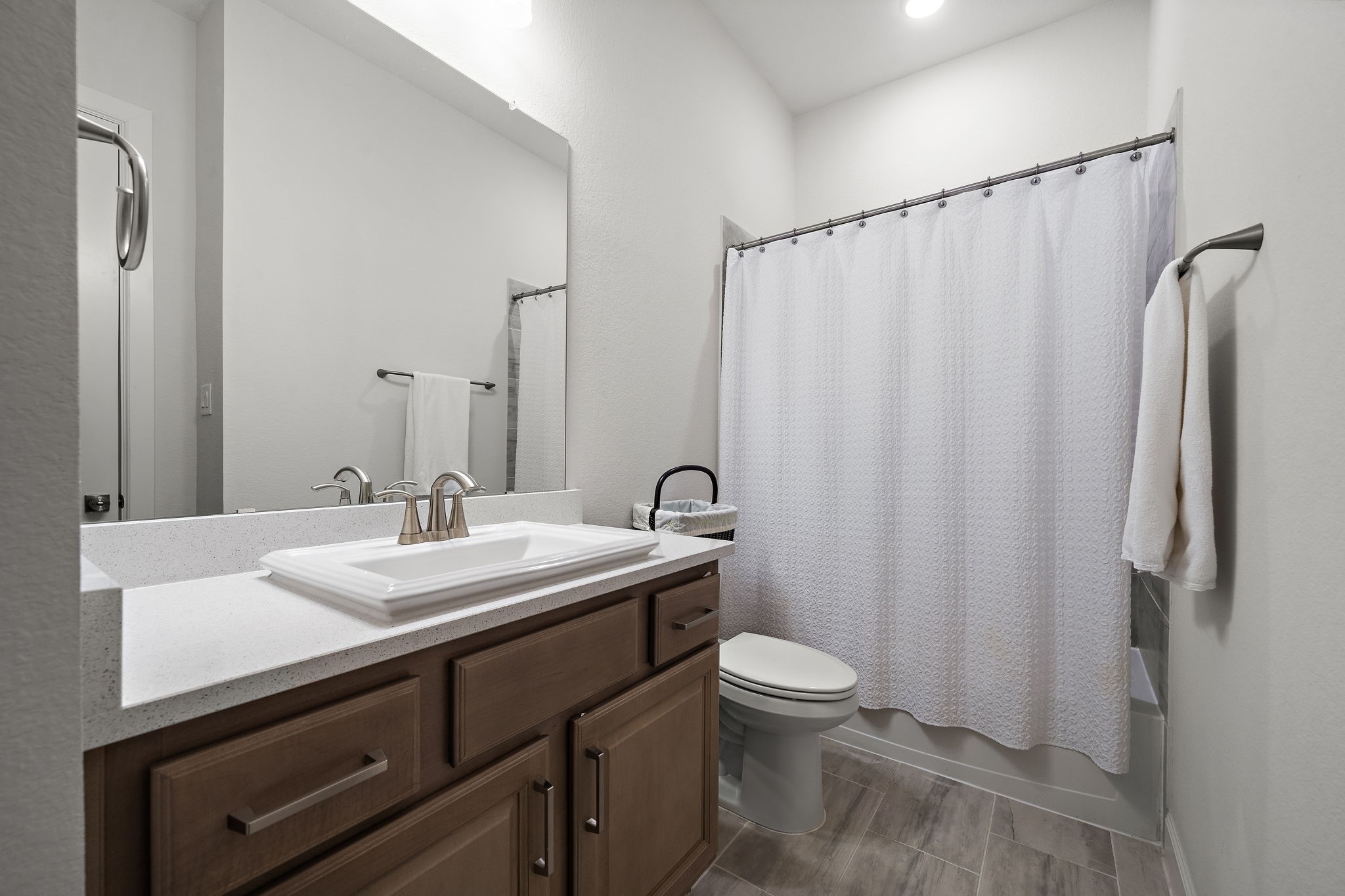 7519 Congress Trl Way Porter, TX 77365 - Photo 28 of 44 a bathroom with a sink a toilet a mirror and shower curtain