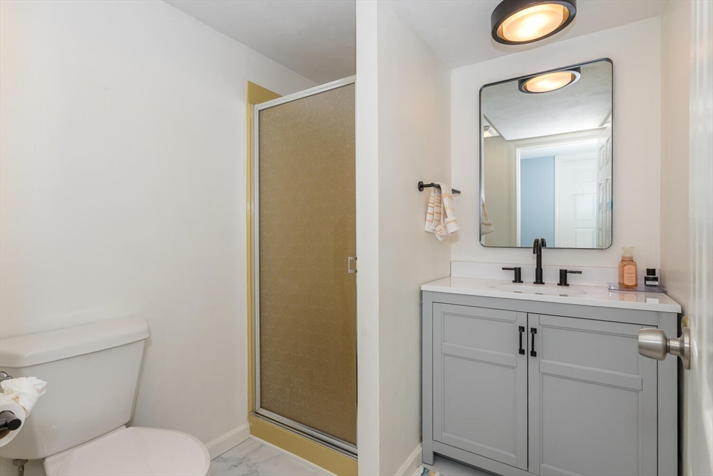 74 Cedarcrest Road Canton, MA 02021 - Photo 27 of 28 a bathroom with a toilet sink vanity and mirror