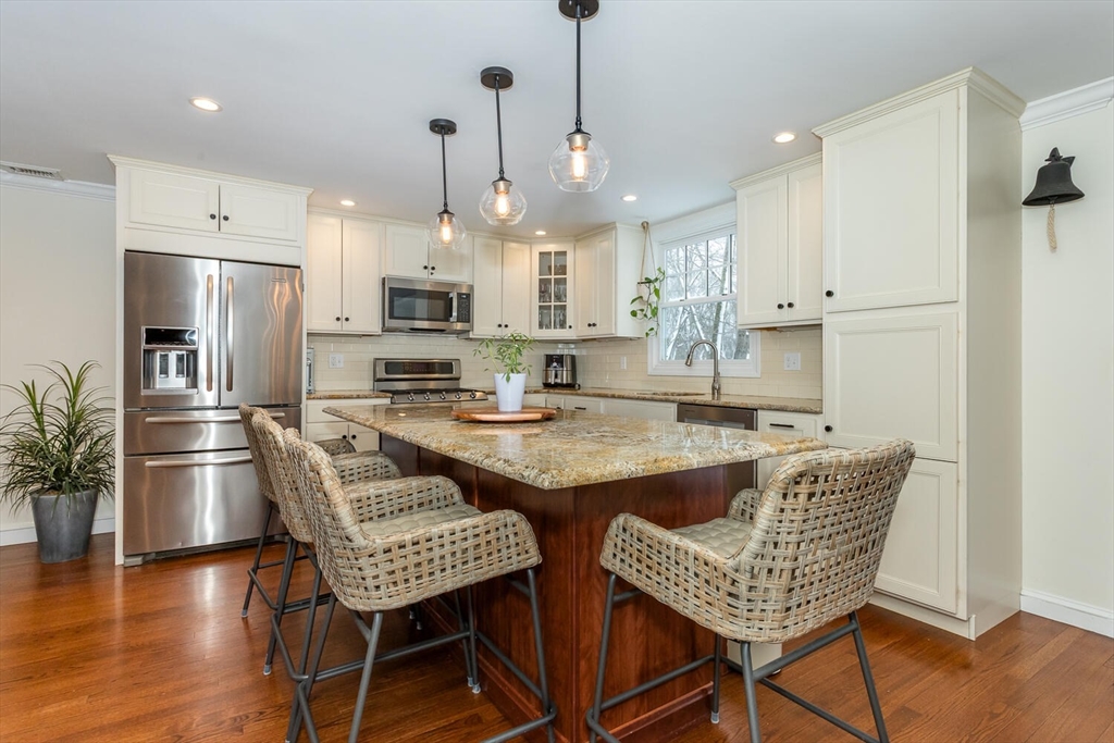 74 Cedarcrest Road Canton, MA 02021 - Photo 7 of 28 a kitchen with stainless steel appliances granite countertop a table chairs stove a refrigerator and a living room view