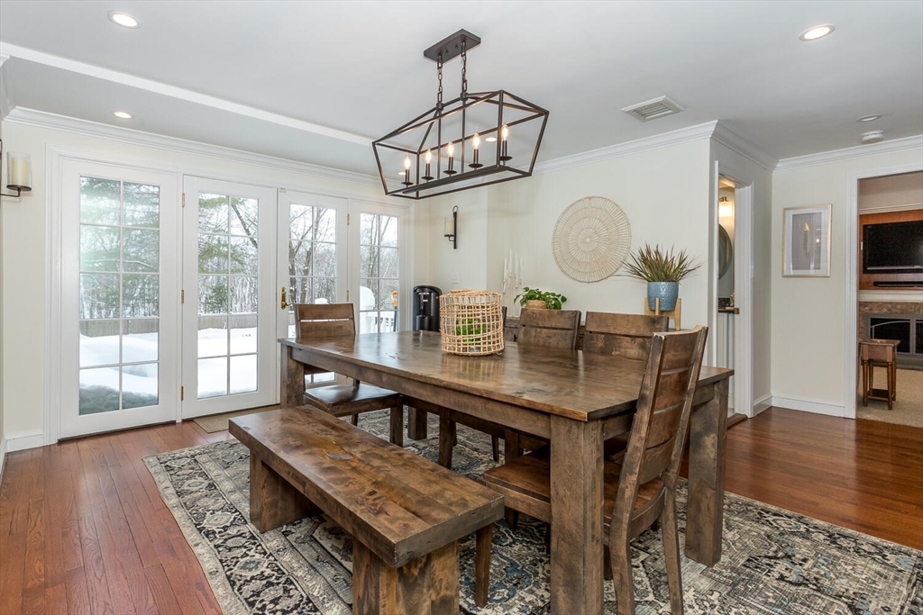 74 Cedarcrest Road Canton, MA 02021 - Photo 9 of 28 a dining room with wooden floor a chandelier a wooden table and chairs