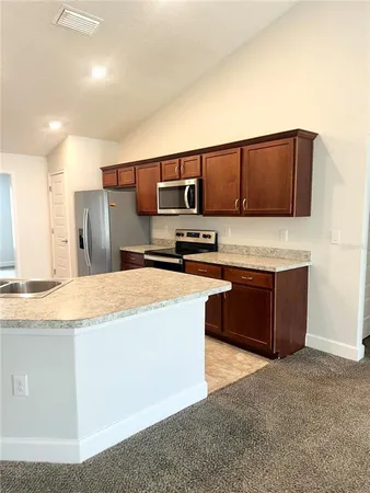a kitchen with stainless steel appliances granite countertop a sink a stove and a refrigerator