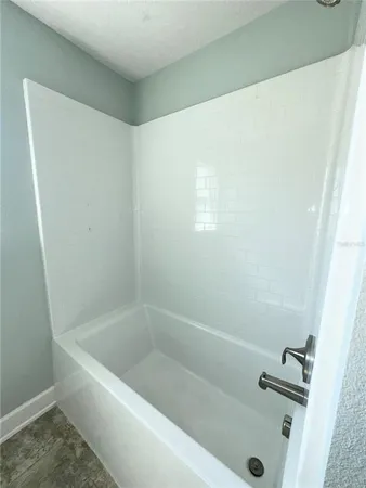 a bath tub sitting next to a white sink