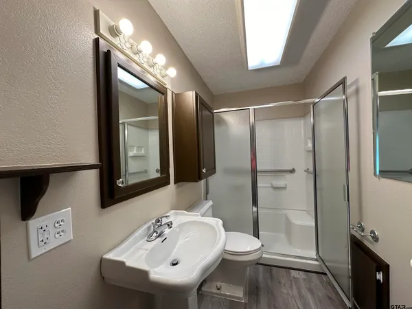 a bathroom with a sink a toilet and shower