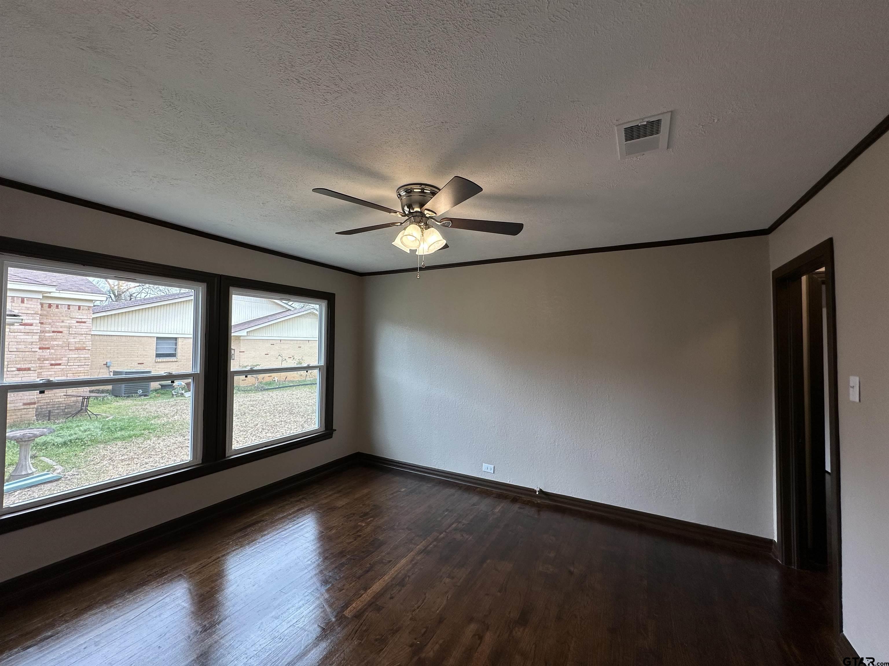 1118 East Main Street Atlanta, TX 75551 - Photo 20 of 34 an empty room with wooden floor and windows