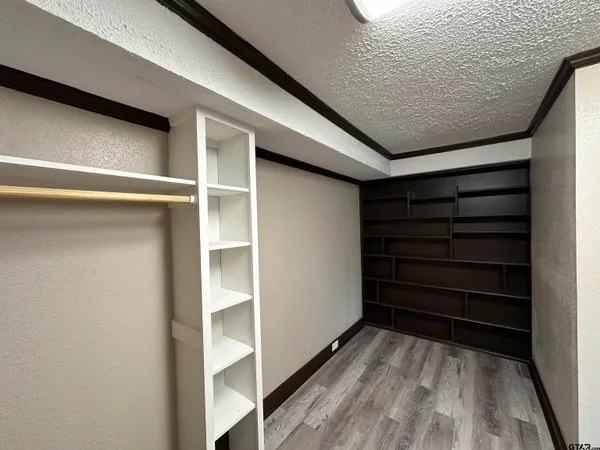 a view of a hallway with wooden floor and a window