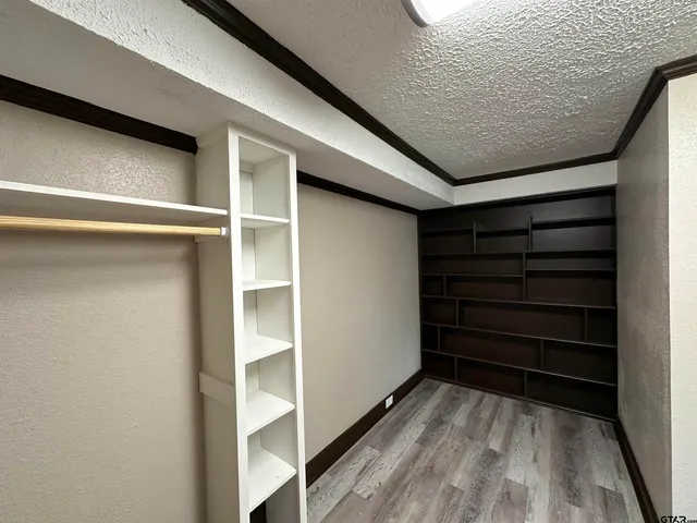 a view of a hallway with wooden floor and a window