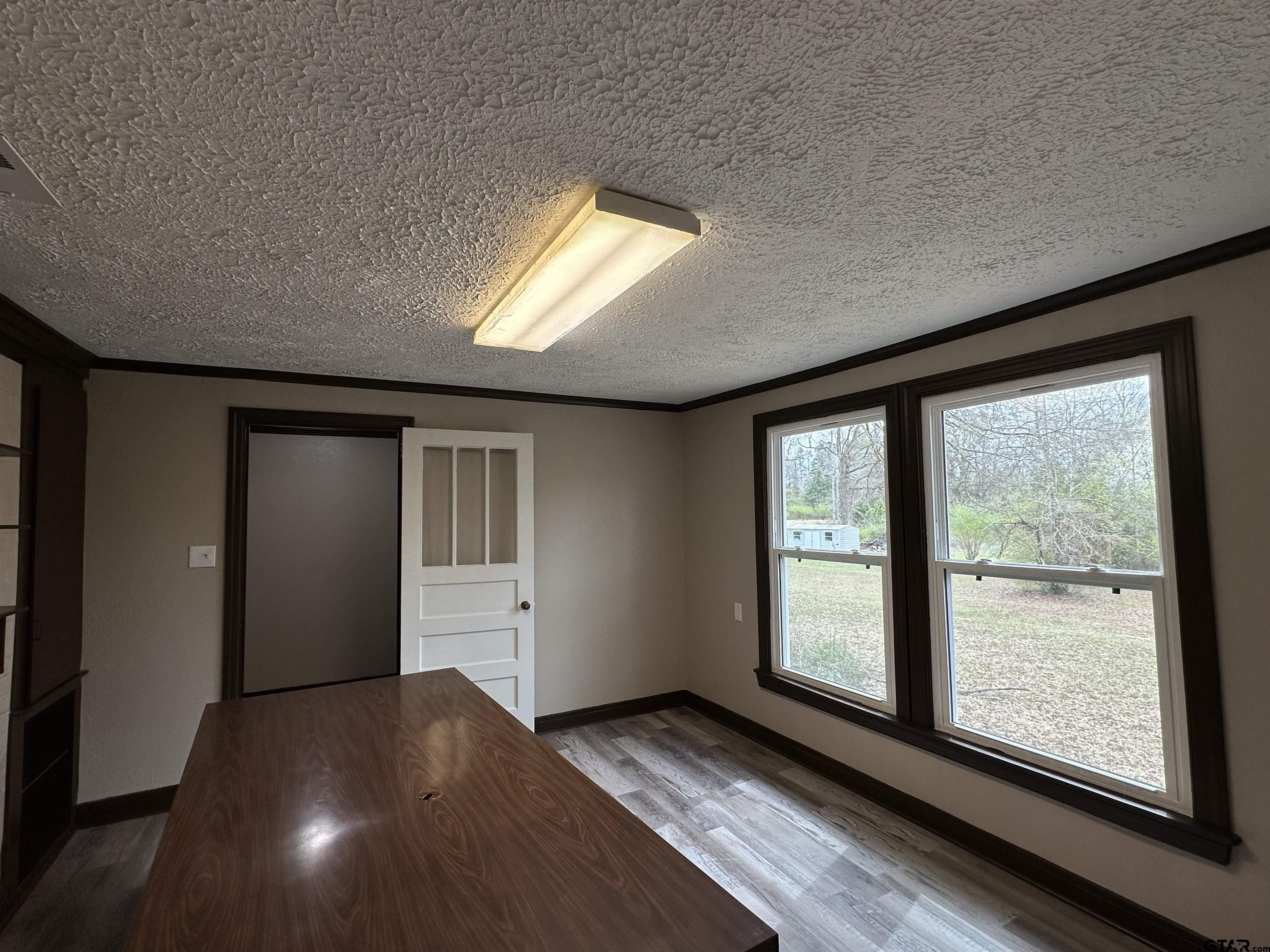 1118 East Main Street Atlanta, TX 75551 - Photo 28 of 34 a view of an empty room with wooden floor and a window