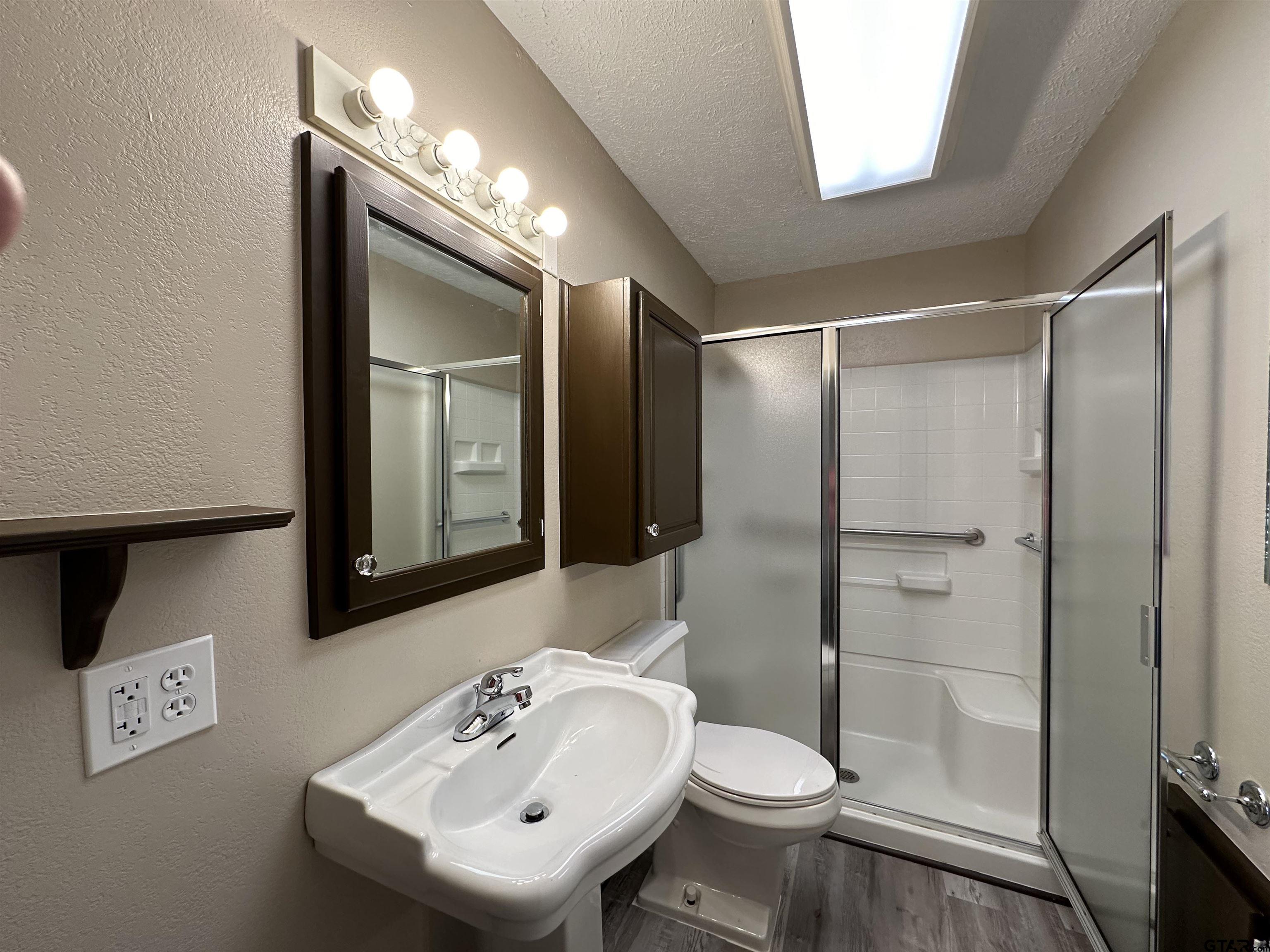 1118 East Main Street Atlanta, TX 75551 - Photo 3 of 34 a bathroom with a sink a toilet and shower