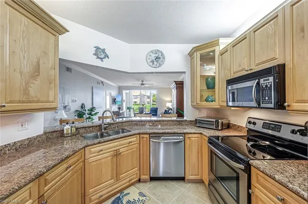 a kitchen with a sink cabinets stainless steel appliances and a window