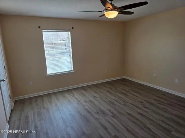 wooden floor in an empty room with a window