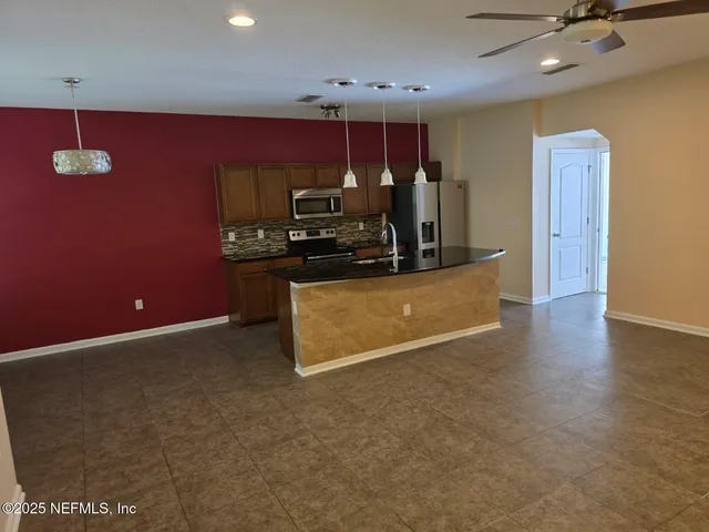 a kitchen with kitchen island a counter top space a sink and a refrigerator