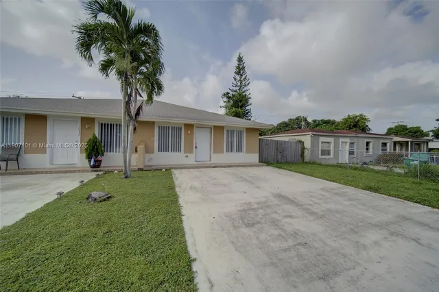 a front view of a house with a garden and trees