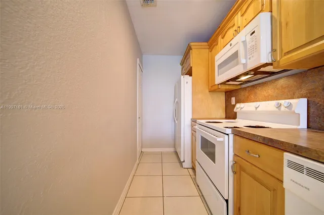a view of a kitchen with white cabinets and a stove top oven