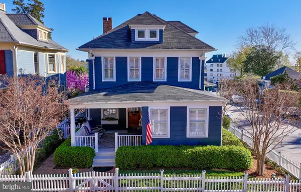 a view of a dining room and livingroom with furniture wooden floor a chandelier