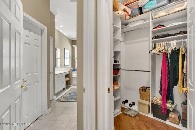 a view of walk in closet with clothes and shoes