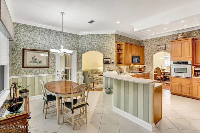 a kitchen with stainless steel appliances a dining table and chairs