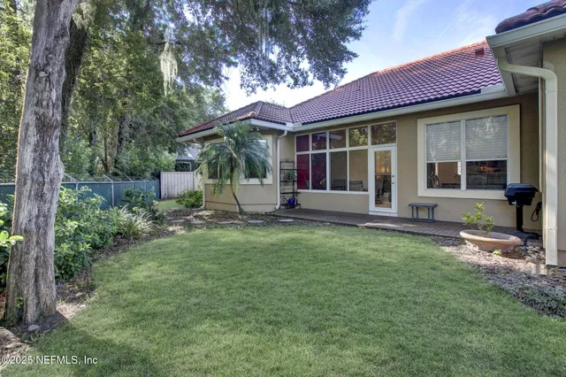 a view of a house with backyard garden and sitting area
