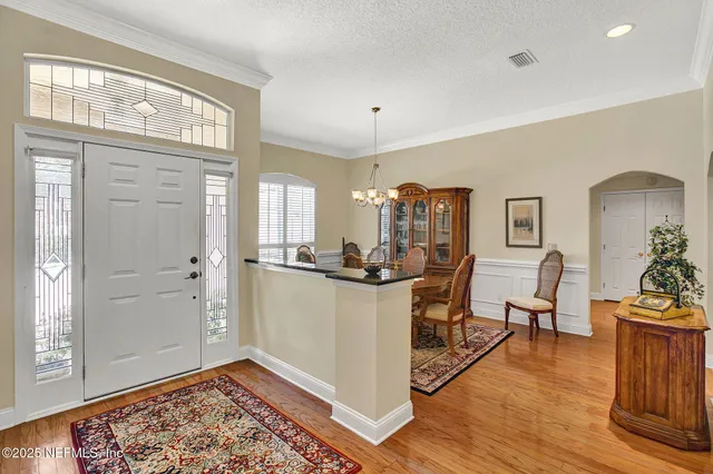 a living room with stainless steel appliances granite countertop furniture and a wooden floor