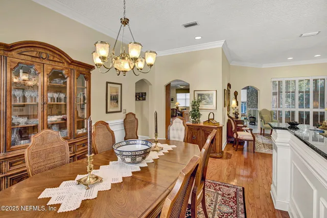 a view of a dining room with furniture a chandelier and wooden floor