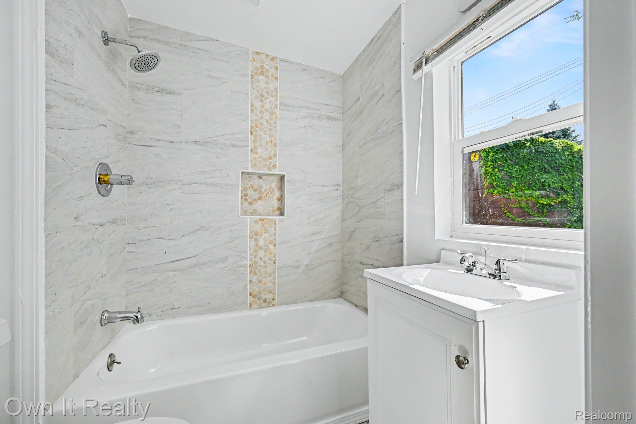 44 Maple Street River Rouge, MI 48218 - Photo 16 of 33 Bathtub with tiled surround, shower niche, and mosaic accent