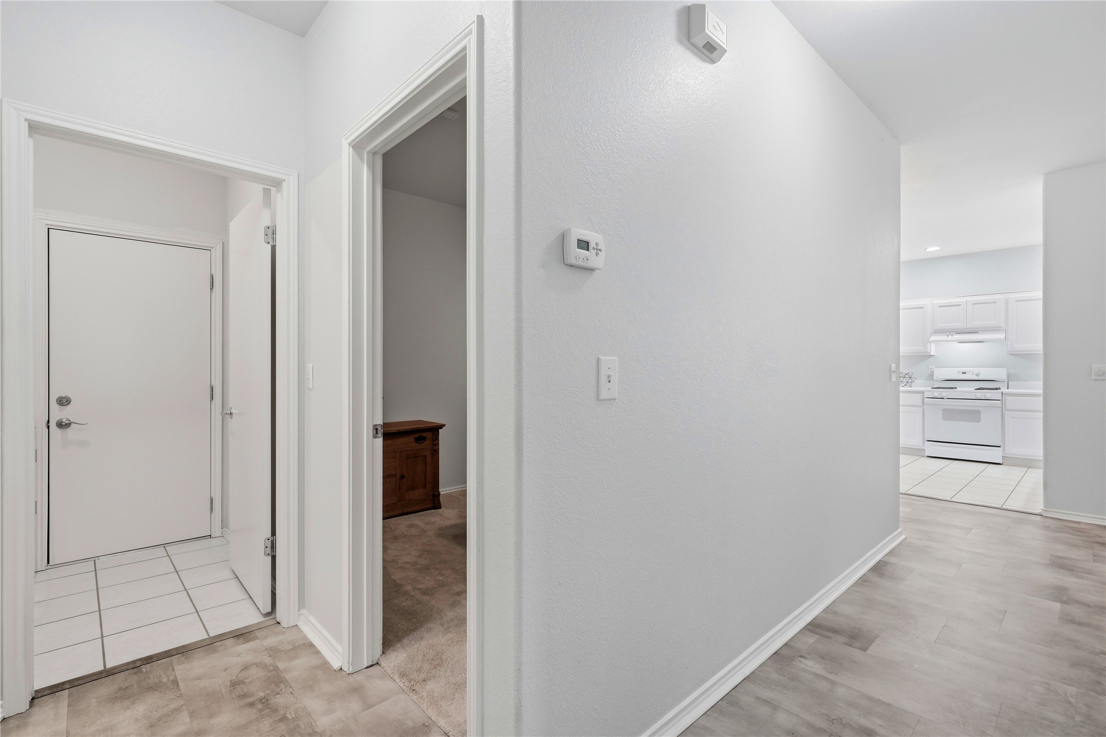 117 Whitewing Way Georgetown, TX 78633 - Photo 16 of 27 A well-lit hallway with durable luxury vinyl flooring connects to the laundry room which leads to the garage.