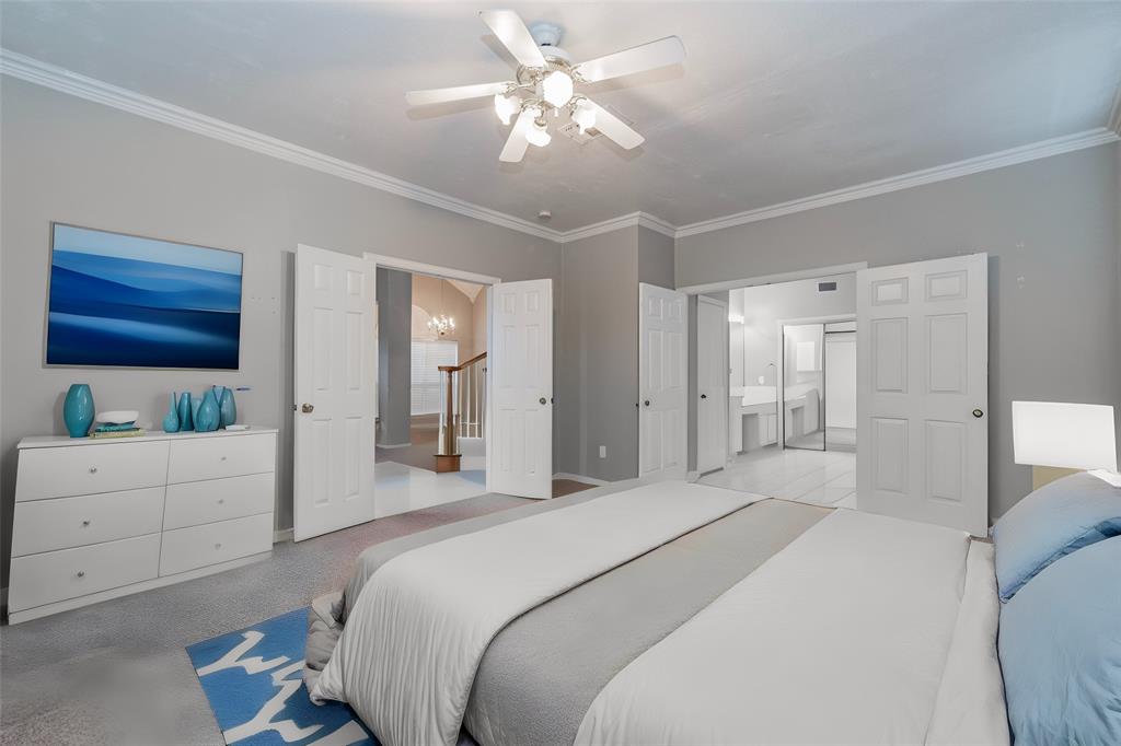 112 Midcrest Drive Irving, TX 75063 - Photo 18 of 37 a bedroom with a bed and a chandelier