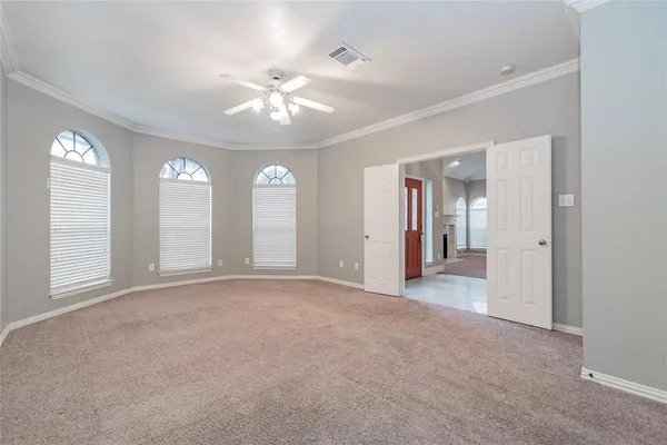 a view of a big room with windows and chandelier fan