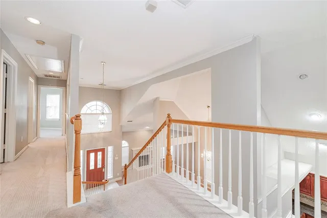 a view of staircase with lots of frames on wall and a window