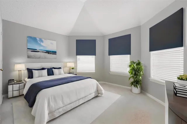 a bedroom with a large bed and a potted plant