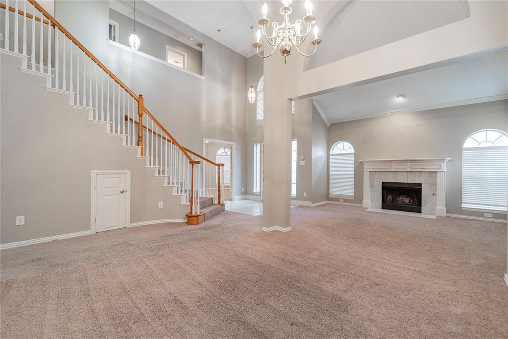 112 Midcrest Drive Irving, TX 75063 - Photo 9 of 37 a view of a livingroom with a fireplace stairs and a chandelier