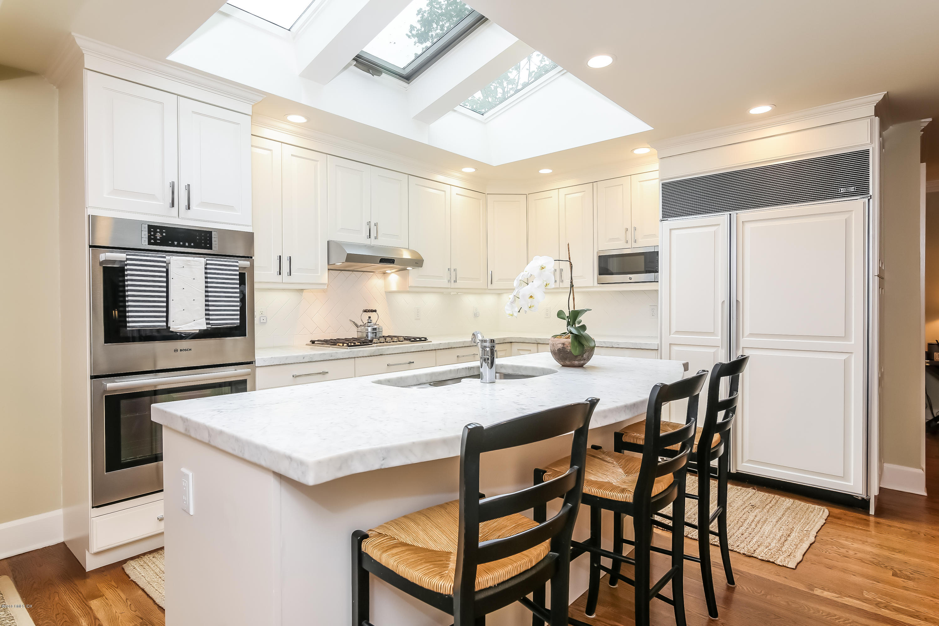 219 Riverside Avenue Riverside, CT 06878 - Photo 15 of 40 a kitchen with stainless steel appliances kitchen island granite countertop a kitchen island and chairs in it