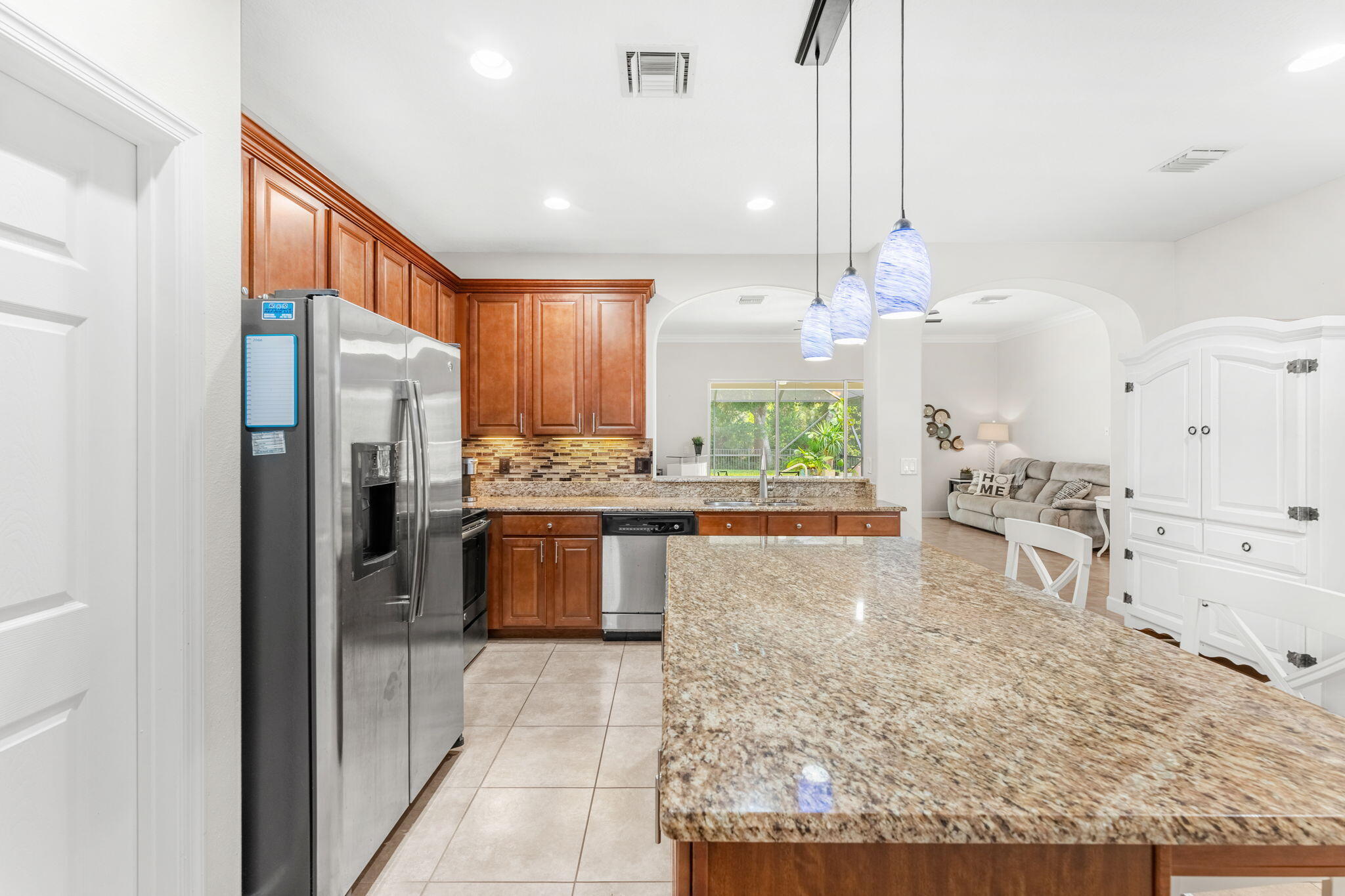 7657 Fieldstone Ranch Square Vero Beach, FL 32967 - Photo 24 of 52 a large kitchen with kitchen island a large counter top stainless steel appliances and cabinets