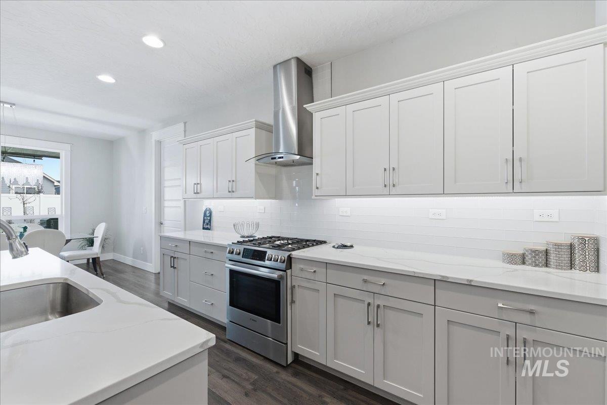 5154 South Twilight Mist Way Meridian, ID 83642 - Photo 18 of 47 Kitchen with stainless steel range with gas stovetop, dark wood finished floors, light stone counters, white cabinets, and recessed lighting