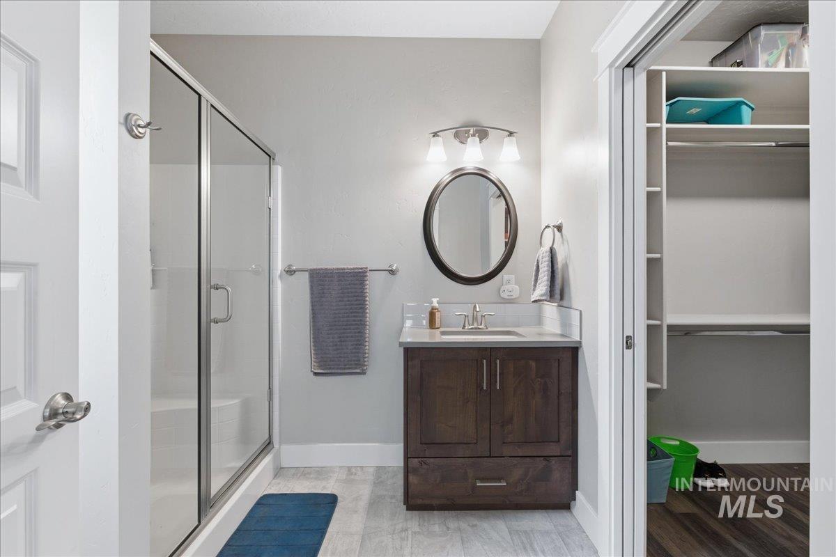 5154 South Twilight Mist Way Meridian, ID 83642 - Photo 33 of 47 Full bath with vanity, a shower stall, a walk in closet, and light wood-style floors