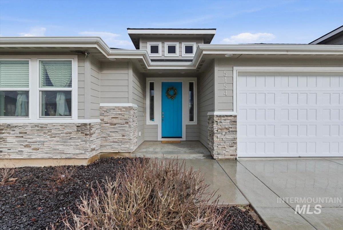 5154 South Twilight Mist Way Meridian, ID 83642 - Photo 5 of 47 Property entrance with stone siding, an attached garage, concrete driveway, and covered porch