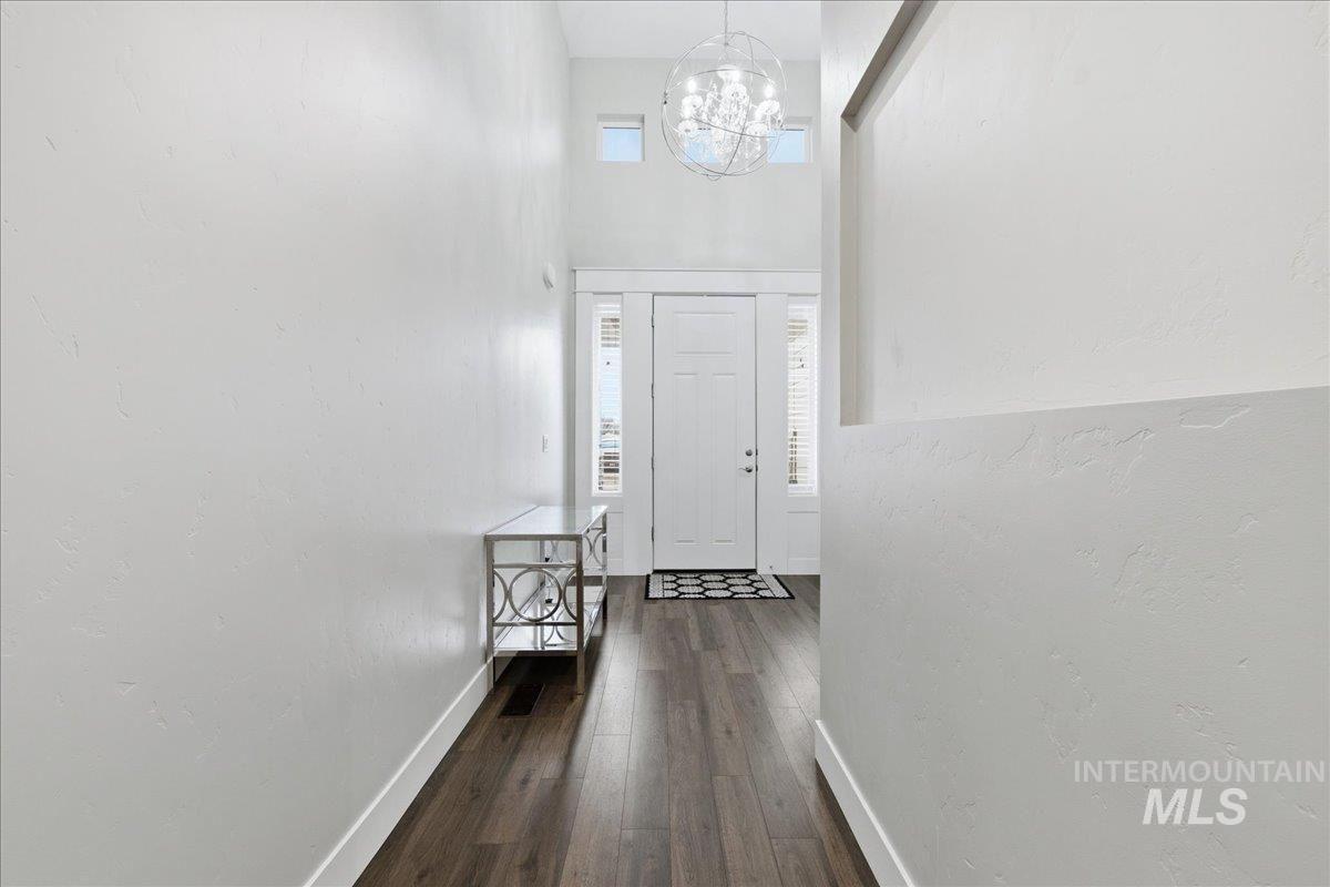 5154 South Twilight Mist Way Meridian, ID 83642 - Photo 7 of 47 Foyer entrance featuring a high ceiling, dark wood-type flooring, healthy amount of natural light, and suspended lighting
