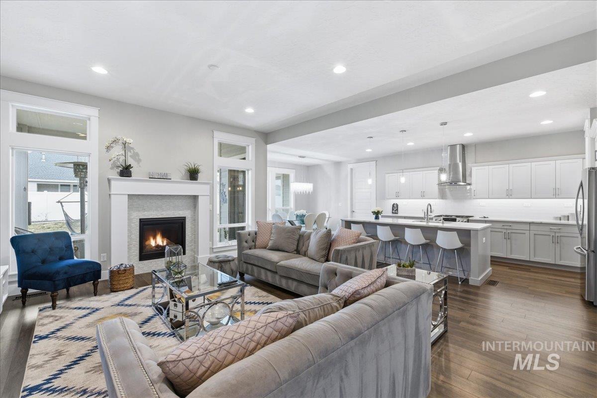 5154 South Twilight Mist Way Meridian, ID 83642 - Photo 8 of 47 Living area featuring dark wood-style floors, a glass covered fireplace, and recessed lighting