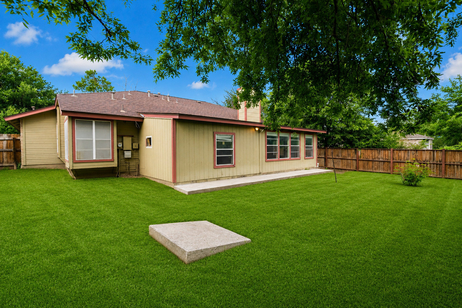 5611 Meadow Crest Austin, TX 78744 - Photo 4 of 29 A vibrant green lawn extends behind this charming single-story residence with a concrete patio for outdoor enjoyment.