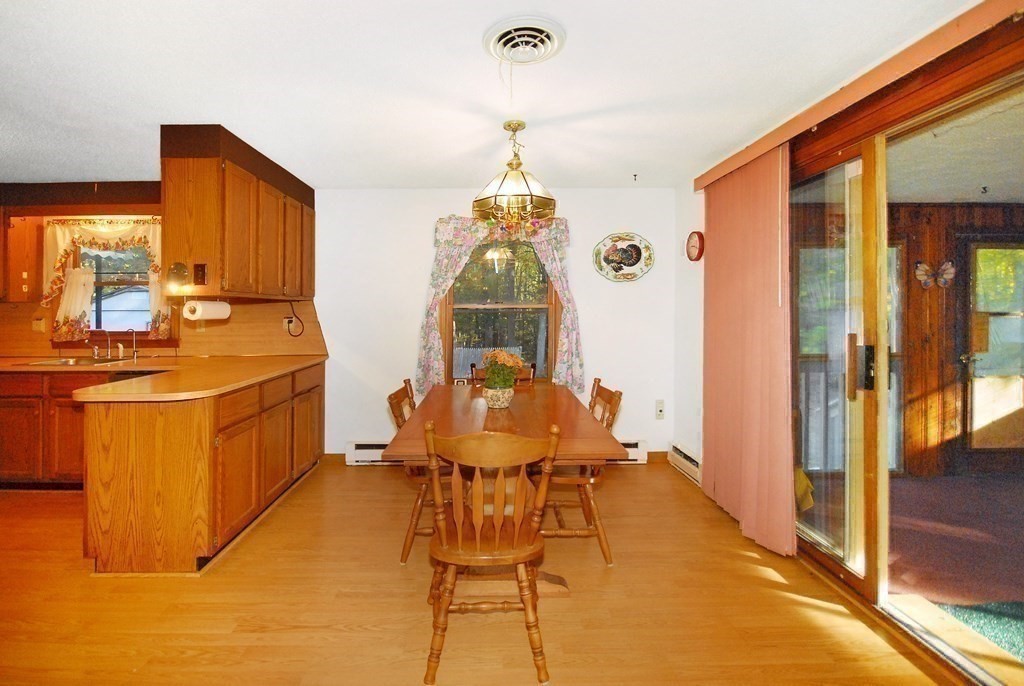 38 Blanchard Road Harvard, MA 01451 - Photo 9 of 26 a dining room with stainless steel appliances kitchen island granite countertop a table chairs in it and a window