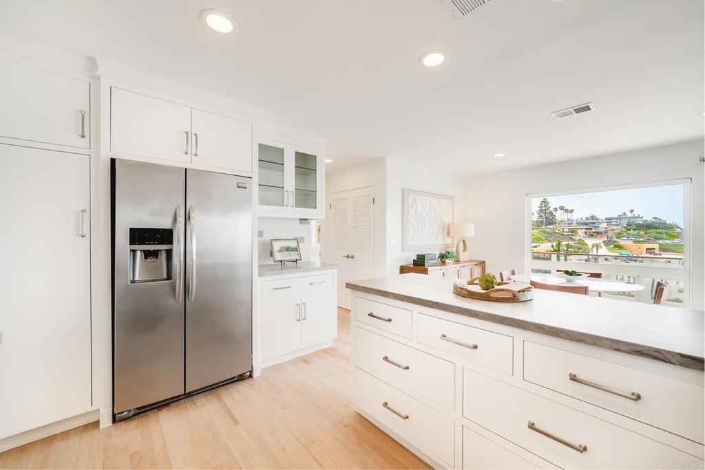 231 5th Street Encinitas, CA 92024 - Photo 20 of 57 a kitchen with white cabinets and stainless steel appliances