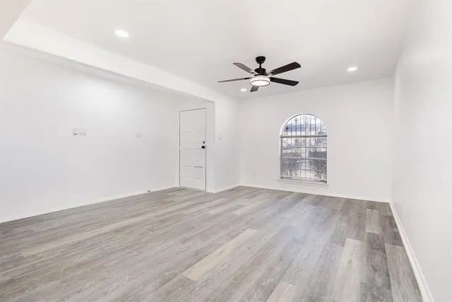 a large kitchen with stainless steel appliances kitchen island a sink dishwasher a stove and white cabinets with wooden floor