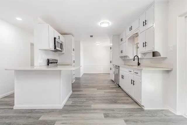 a kitchen with stainless steel appliances a stove microwave and sink