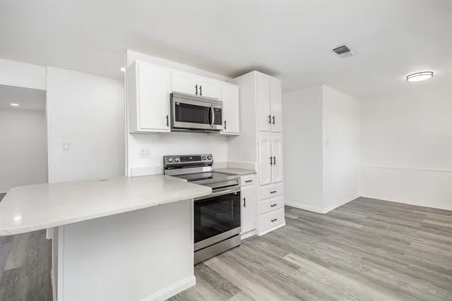 a kitchen with a sink cabinets and wooden floor