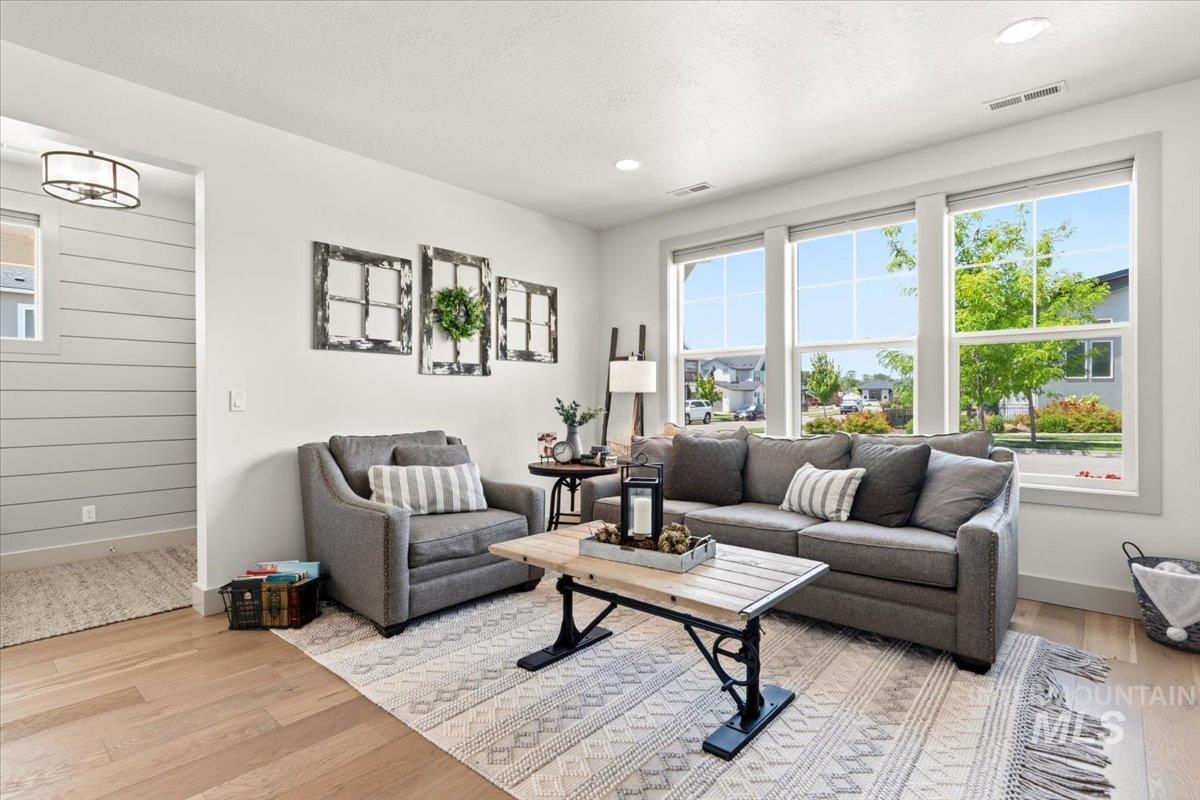 3794 South Single Tree Avenue Boise, ID 83716 - Photo 12 of 50 Living area featuring light wood-finish flooring, recessed lighting, and a wall of three large windows