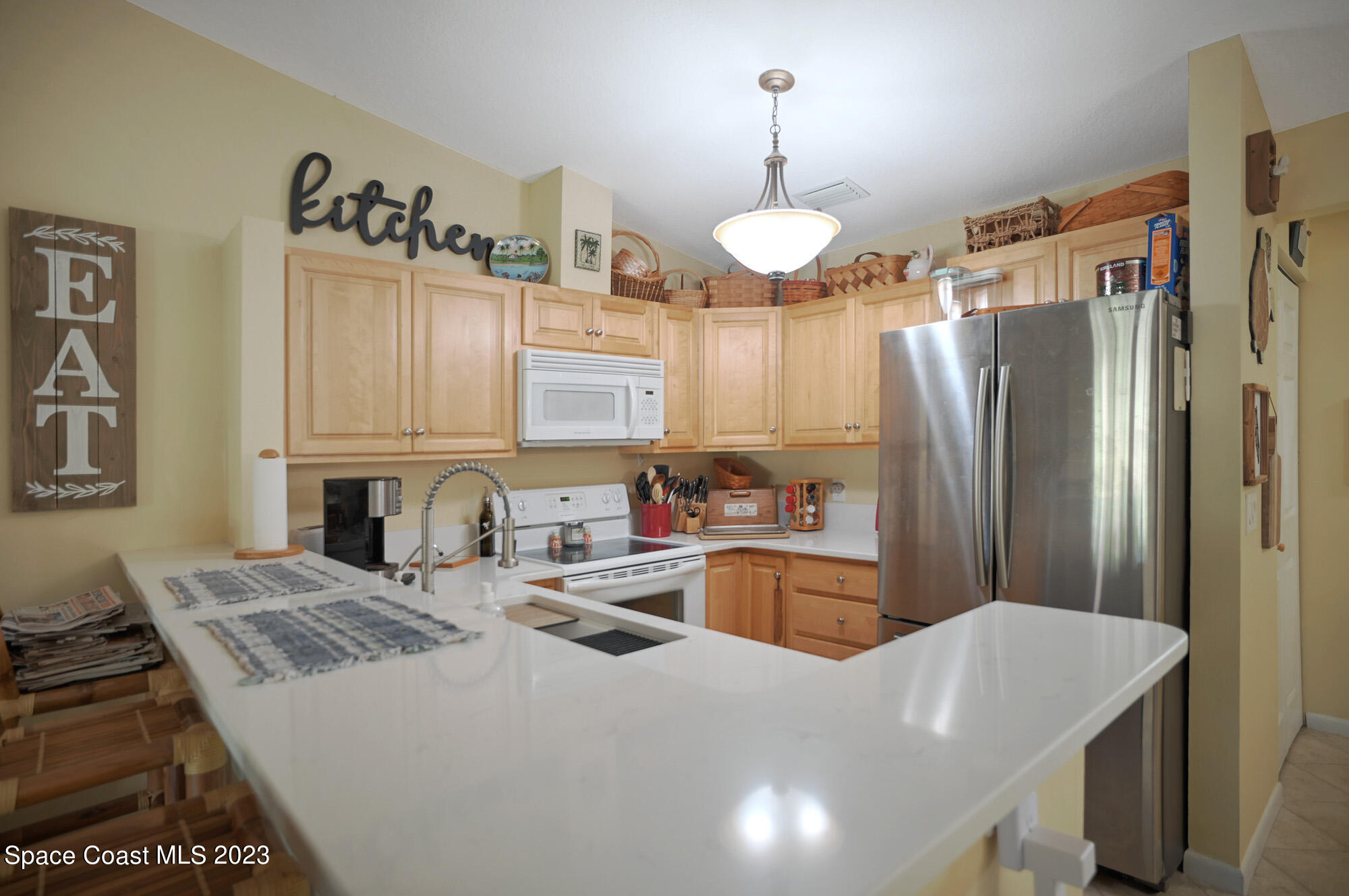 116 Normandy Place Melbourne Beach, FL 32951 - Photo 7 of 24 a kitchen with cabinets a sink stainless steel appliances and a counter top space
