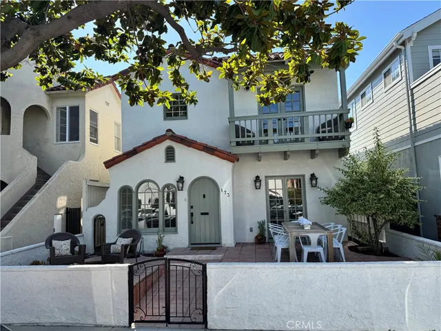a view of a white house with large trees and outdoor space