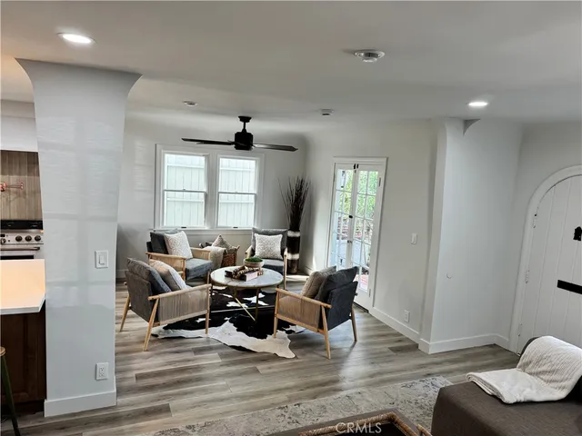 a living room with furniture kitchen view and a chandelier